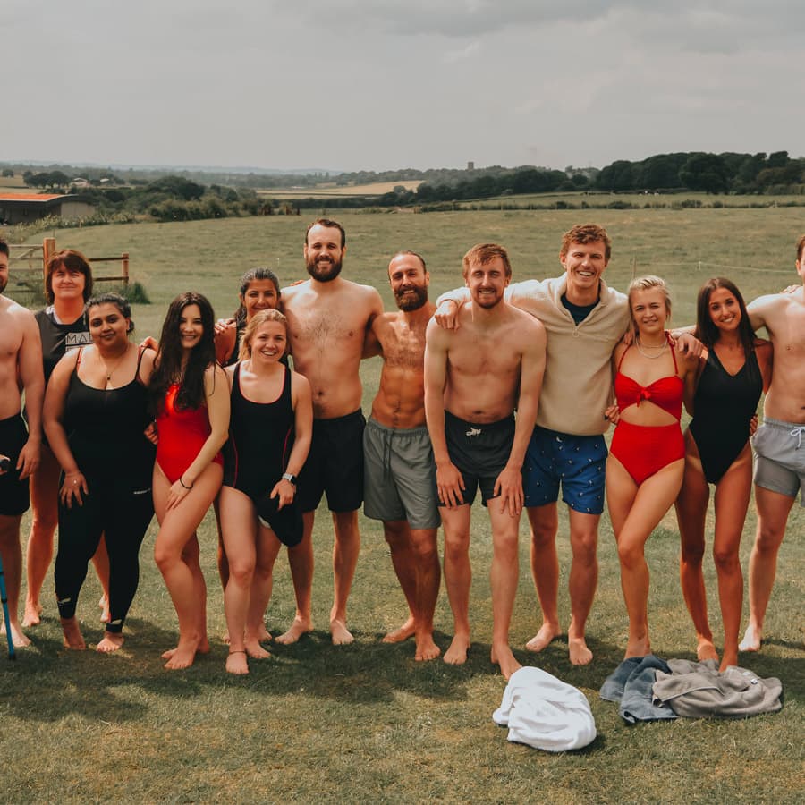 The Farm Club team standing together in the fields by the lake
